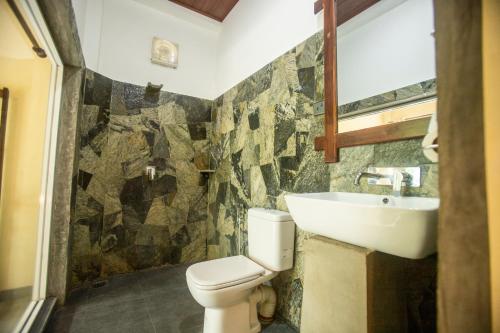 a bathroom with a toilet and a sink at Evergreen Hotel Dambulla in Dambulla