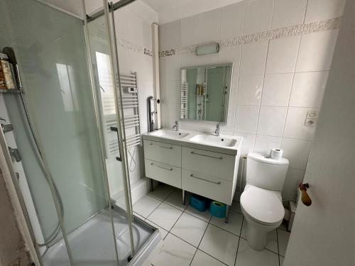 ein Bad mit einem WC, einem Waschbecken und einer Dusche in der Unterkunft Les Fleurons in Ambleteuse