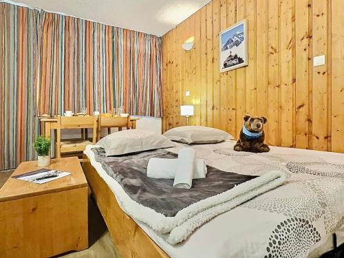 un chien assis sur un lit dans une chambre dans l'établissement Studio 4 pers avec parking, Tignes - FR-1-411-904, à Tignes