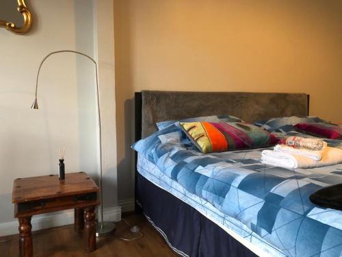 a bedroom with a bed with a table next to it at Cosy apartment for 2 just 5 mins from Newbridge 