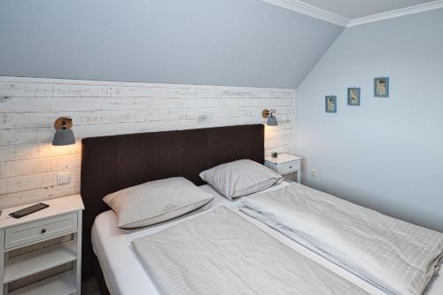 um quarto com uma cama grande e uma cabeceira em madeira em Haus Mühlentrift, FeWo 03 em Döse