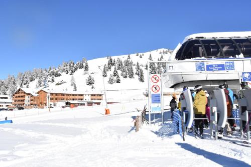 a group of people on a ski lift in the snow at Hotel La Baita in Folgaria