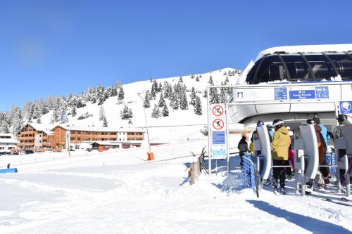 een groep mensen op een skilift in de sneeuw bij Hotel La Baita in Folgaria