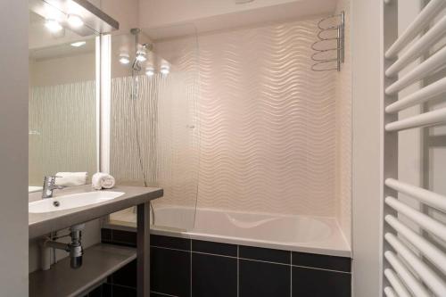 une salle de bain avec douche et lavabo dans l'établissement Les Thermes 511 - Appt proche plage avec piscine partagée, à Concarneau