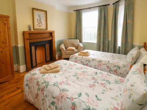 a living room with two beds and a fireplace at Tidal Reach in Paignton