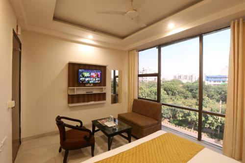 a living room with a tv and a chair and a table at GREEN LOTUS SAI INTERNATIONAL in New Delhi