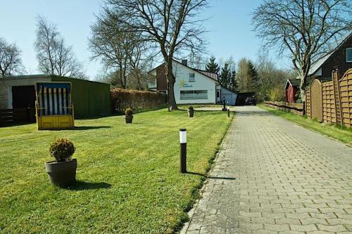 einen Rasenplatz mit Spielplatz und Haus in der Unterkunft Haus Sonneck, App 2 in Duhnen