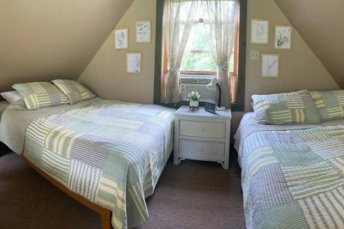 a bedroom with two beds and a window at Secluded Cabin on Red Haven Farm in Irvine