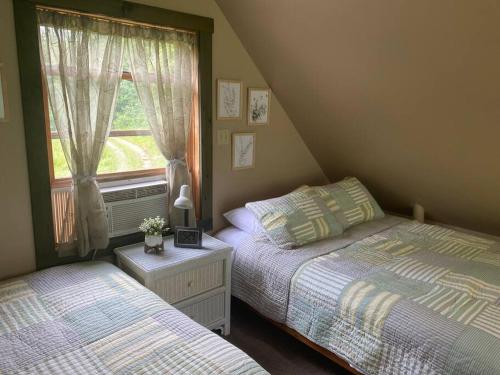 1 dormitorio con 2 camas junto a una ventana en Secluded Cabin on Red Haven Farm, en Irvine