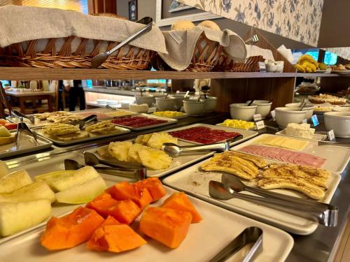 um buffet com muitos tipos diferentes de comida em exposição em Pousada Gramado em Gramado