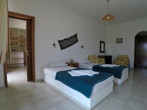 1 dormitorio con 2 camas y sofá en Milos Apartments, en Elounda