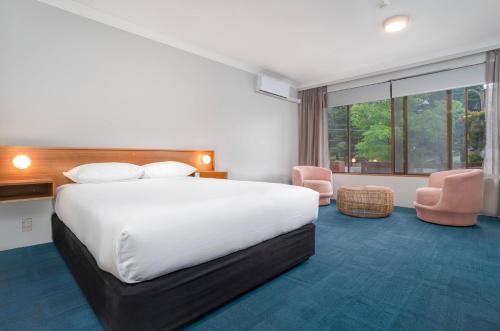 pokój hotelowy z łóżkiem i dużym oknem w obiekcie All Seasons Motel Armidale w mieście Armidale
