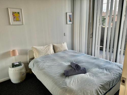 een slaapkamer met een bed met een handdoek erop bij New Comfy stylish Apt in Rhodes Next to train n shopping center in Sydney