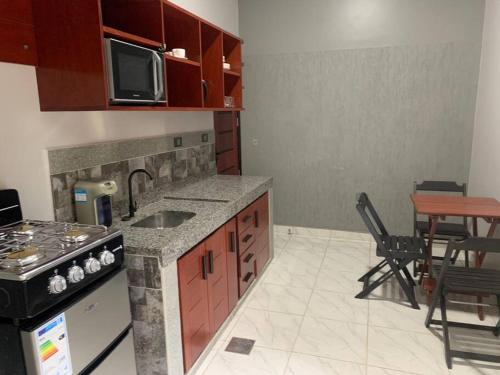 a kitchen with a sink and a stove top oven at Acogedora casa en Cobija in Tres Puentres