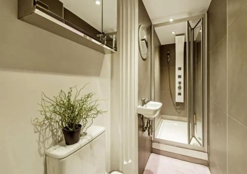 een badkamer met een toilet en een wastafel met een plant bij Live the London life in Notting hill in Londen