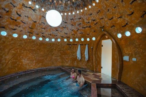 two people in a swimming pool with birds on the ceiling at Pousada do Capão Chapada Diamantina in Vale do Capao