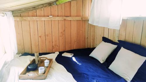 1 dormitorio con 1 cama con almohadas azules y blancas en Chambre scandinave dans un parc forestier, en Marval