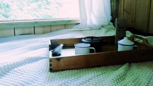 una caja de madera en una cama con 2 teteras y una ventana en Chambre scandinave dans un parc forestier, en Marval