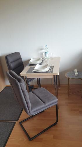 stół z krzesłem i stołem oraz stół i fotel w obiekcie Single-Apartment Essen w Essen