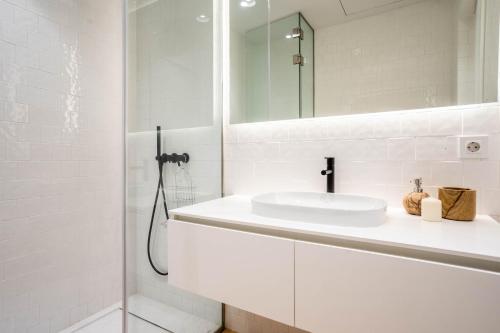 y baño blanco con lavabo y ducha. en Almada 551 - 4 1 Penthouse View by LovelyStay, en Oporto