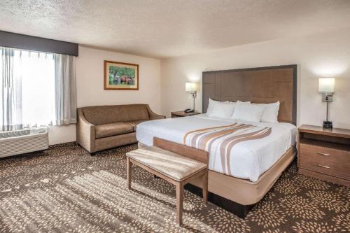 a large hotel room with a bed and a couch at Wenatchee Inn in Wenatchee