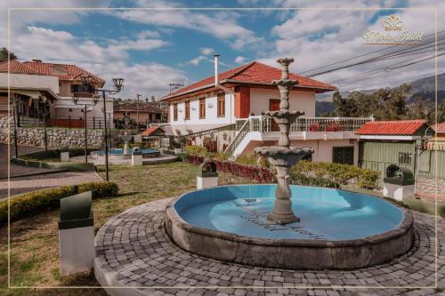 a fountain in a courtyard in front of a house at Quinta maría isabel. Elegante y restaurada in Gualaceo