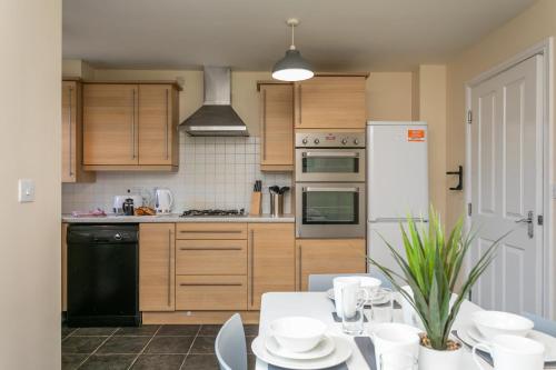 una cocina con una mesa con platos blancos. en The Durham House, en Leyland