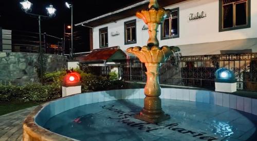 a fountain in front of a house at night at Quinta maría isabel. Elegante y restaurada in Gualaceo
