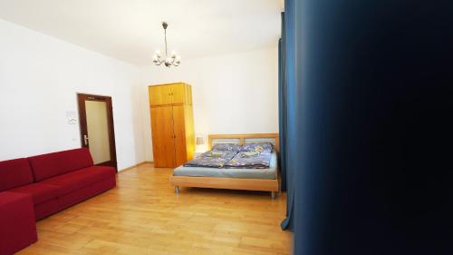 ein Schlafzimmer mit einem Bett und einem roten Sofa in der Unterkunft CozyNite Premium Apartment Hernals 1 in Wien