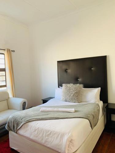 a bedroom with a large bed with a black headboard at Beach View B&B in East London