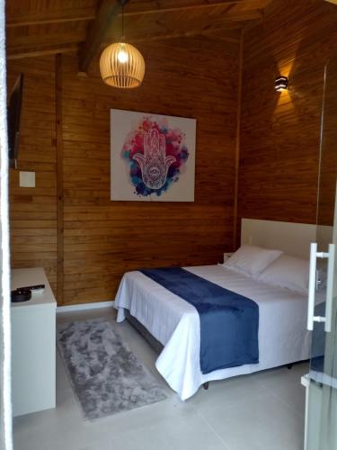 a bedroom with a bed and a painting on the wall at Morada Bem Me Quer in Canela