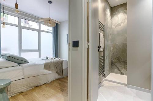 une chambre avec un lit et une douche à l'italienne dans l'établissement MyKeypers - Luxury Apartment 4P - Le Marais / Bastille, à Paris