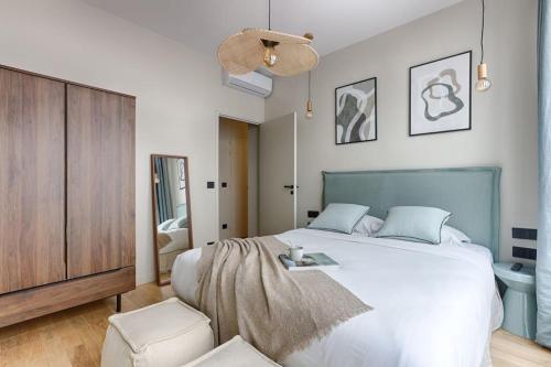 - une chambre avec un grand lit blanc et une commode dans l'établissement MyKeypers - Luxury Apartment 4P - Le Marais / Bastille, à Paris