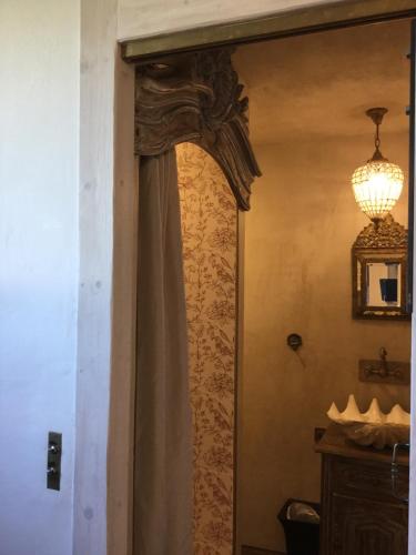 una puerta con una cortina y una lámpara de araña en una habitación en Casa romantica en Chaussy