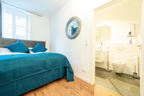 a bedroom with a bed and a mirror and a bathroom at LiT LiVING: Luxus - Box SprIng - WH Old Town in Weinheim