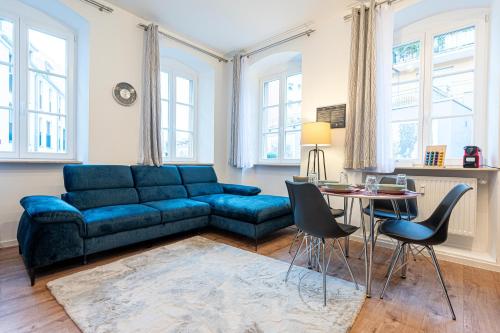 sala de estar con sofá azul y mesa en LiT LiVING: Luxus - Box SprIng - WH Old Town en Weinheim