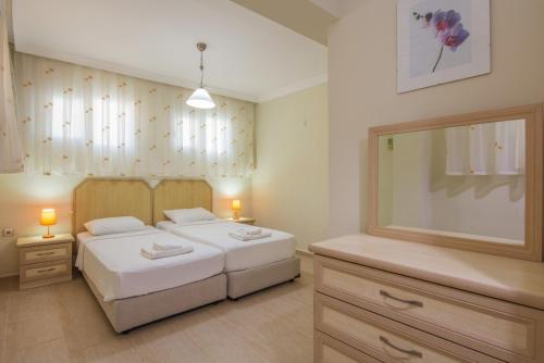 a bedroom with two beds and a large mirror at Golden Trio Villa in Oludeniz