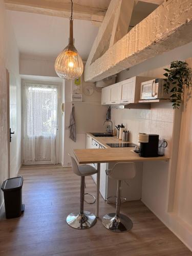 - une cuisine avec un comptoir en bois et une table dans l'établissement Studio Cosy rue Sainte/St Victor, à Marseille
