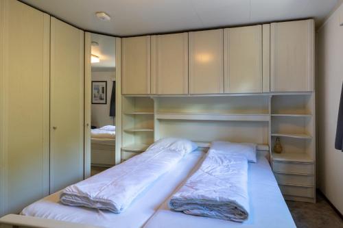 a small bedroom with a bed and cabinets at Bungalowpark Het Verscholen Dorp in Harderwijk