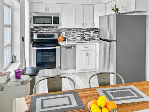 a kitchen with white appliances and a table and chairs at Tropical 2-Bedroom 1-Bath Private Key West-like Home Close To Beach in Pompano Beach