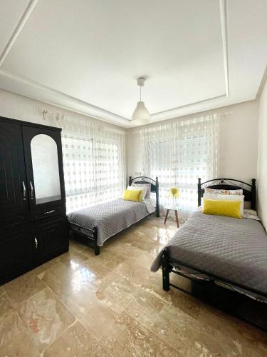 a bedroom with two beds and a window at Appartement Tanger Moulay Ismail in Tangier