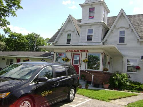 a black car parked in front of a house at Lakelawn B&B and Motel in Yarmouth
