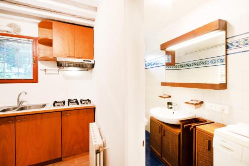 a kitchen with wooden cabinets and a sink at Santa Margherita, casa accogliente e confortevole in Venice