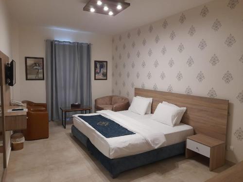 a bedroom with a large bed and a chair at Batroun boutique suites in Batroûn