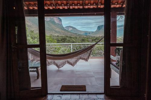 an open door to a balcony with a hammock at Pousada do Capão Chapada Diamantina in Vale do Capao
