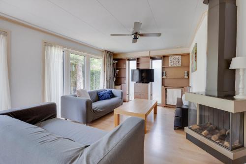 a living room with a couch and a fireplace at Bungalowpark Het Verscholen Dorp in Harderwijk
