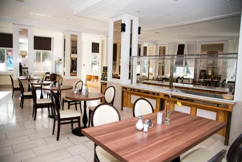 a restaurant with tables and chairs in a room at Hotel Villa Elsa in Bad Kissingen
