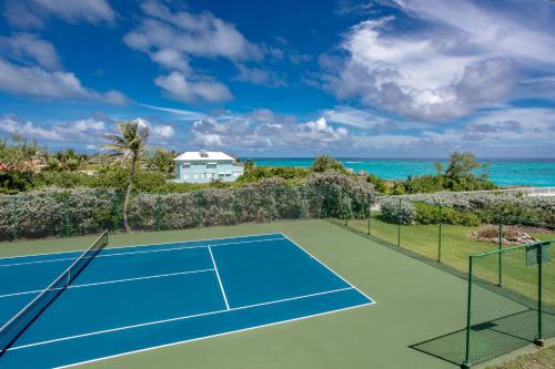 a tennis court with the ocean in the background at Belair Great House - The stunning, private escape with breathtaking views and exquisite surroundings. in Saint Philip