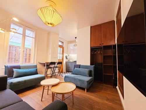 un salon avec des canapés bleus et une table dans l'établissement L'impasse du Mail, à Rouen