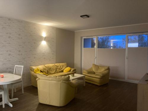 a living room with two couches and a table at Smile Apartment in Osielsko